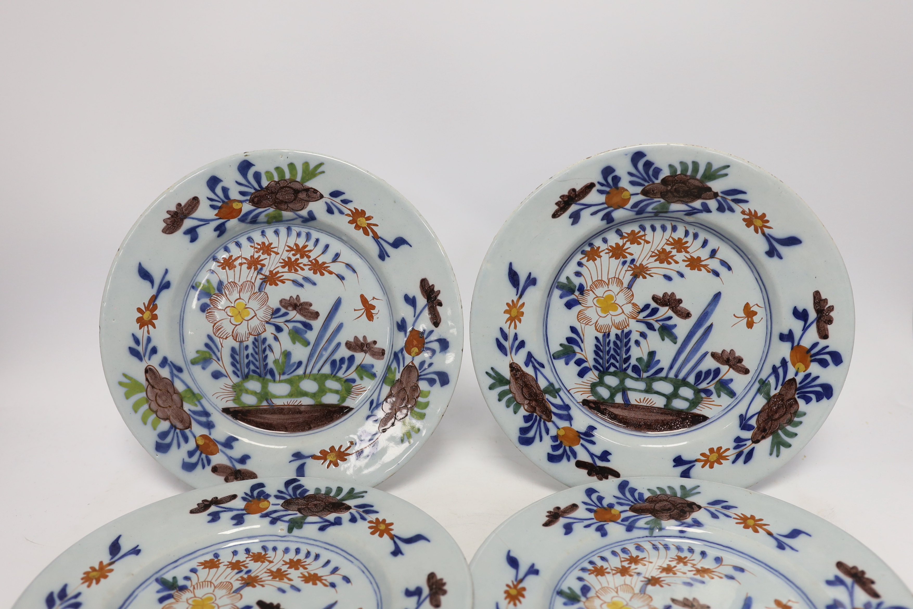 A set of four mid 18th century Delft polychrome floral plates, 22.5cm diameter